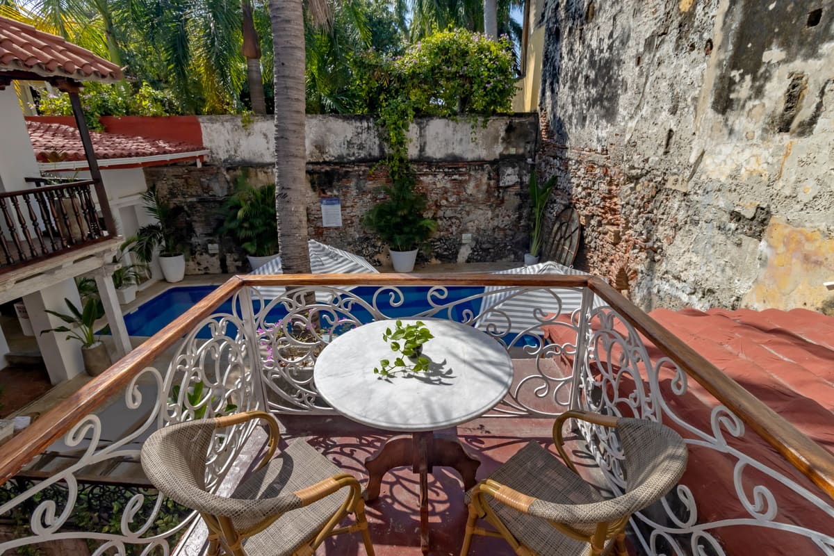 Balcón con vista a la piscina y muros coloniales
