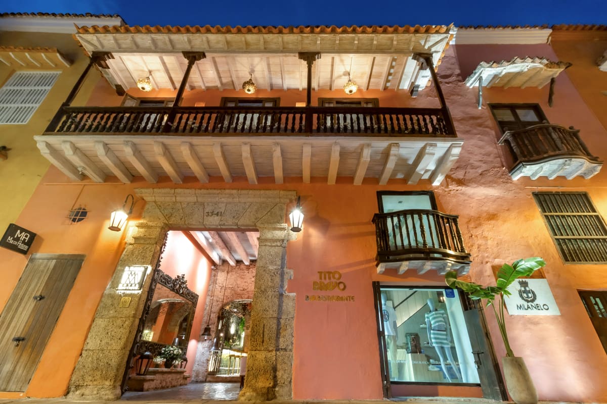 Fachada colonial de noche con balcones de madera