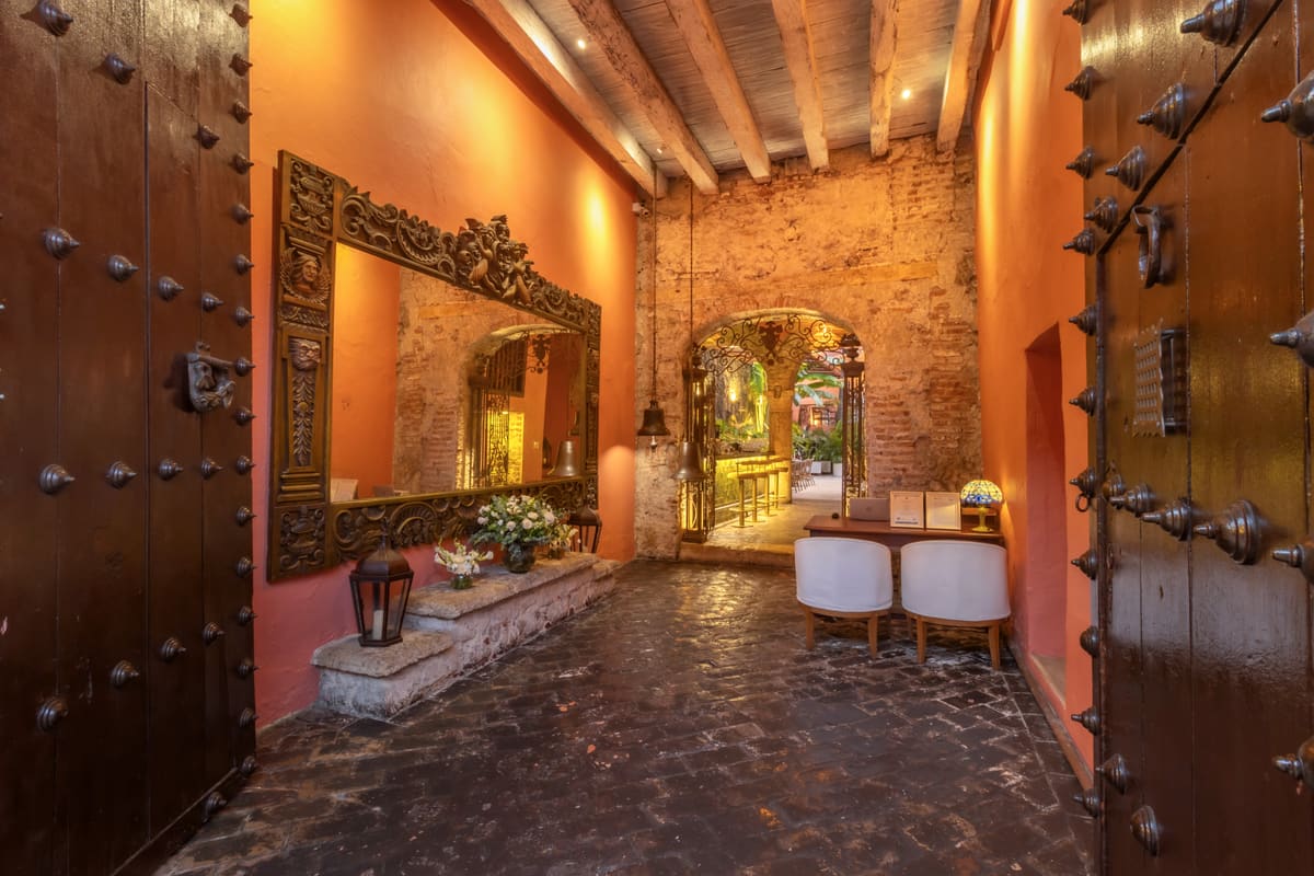 Entrada colonial con puertas talladas y marco dorado